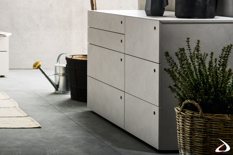 Floor-standing dresser with a simple, linear design marked by horizontal lines, with hole handles flush with the drawers
