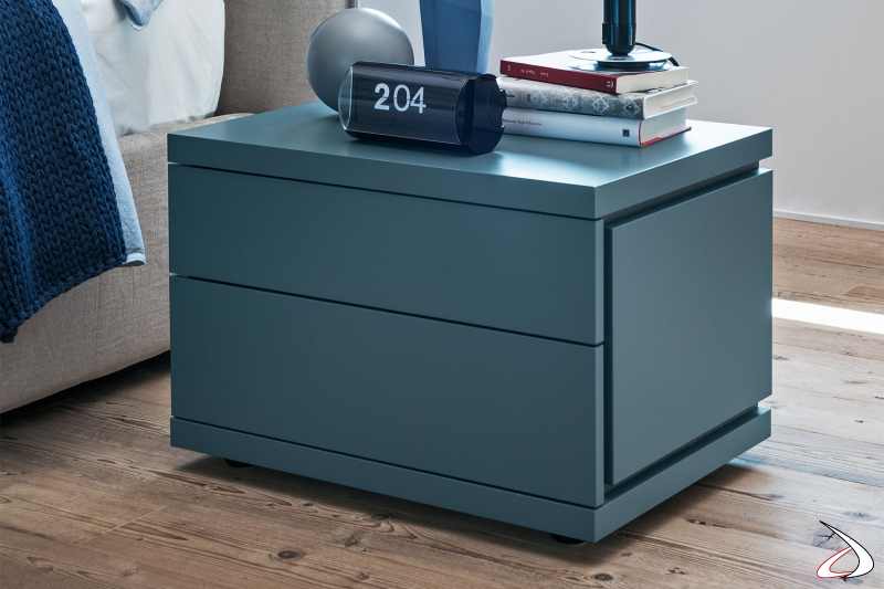 Bedside table with a geometric design characterised by a thick top and base that highlight the front and side grooves. 
