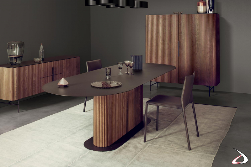 Sala da pranzo di design con tavolo ovale di lusso con piano in metallo e gamba centrale in legno