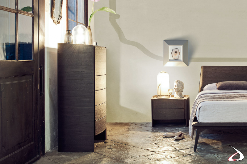 Dormitorio elegante y refinado amueblado con una cómoda de diseño y una mesilla de noche en madera chapada