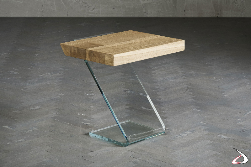 Particolare tavolino caratterizzato da un top massiccio in rovere squadrato, e da un basamento in vetro curvato a caldo.