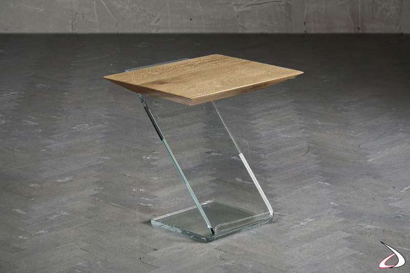 Particolare tavolino caratterizzato da un top massiccio in rovere sagomato, e da un basamento in vetro curvato a caldo 