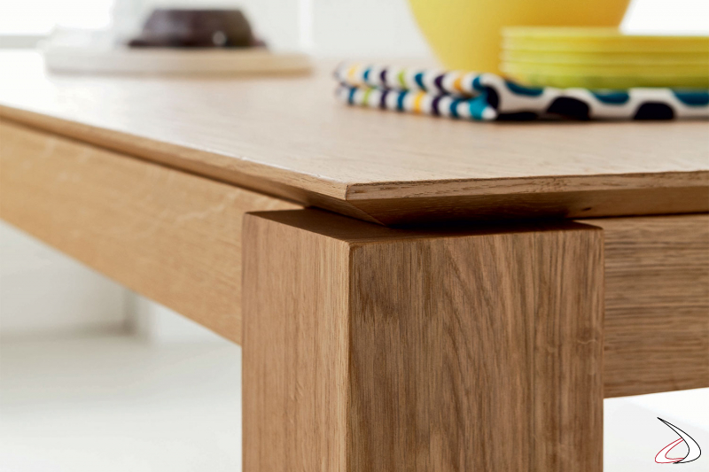 Tavolo in legno massello dal top caratterizzato da un bordo inclinato.