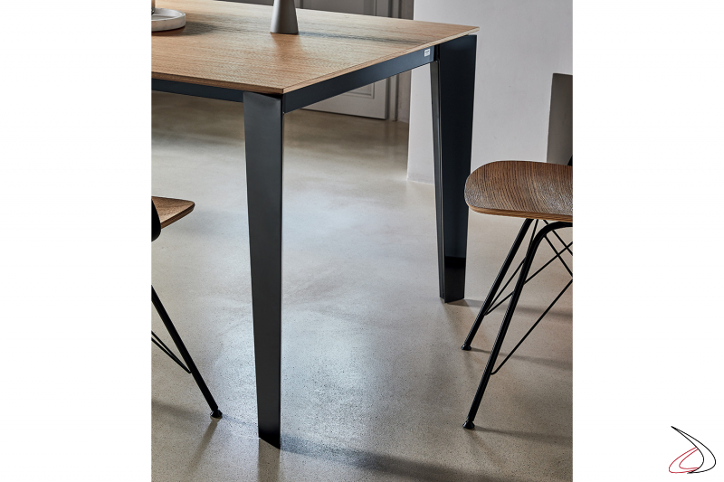 Tavolo di design con gambe nere lucide e piano in melaminico