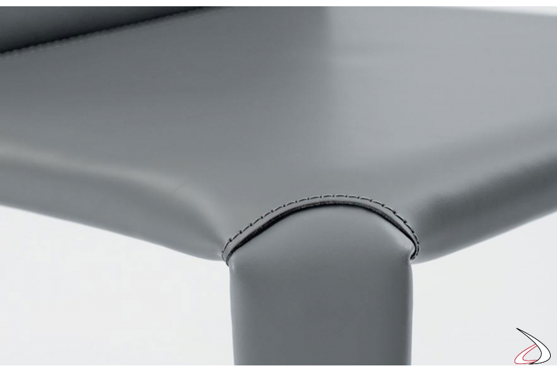 Dettaglio cucitura su cuoio in tinta con il colore grigio chiaro della seduta