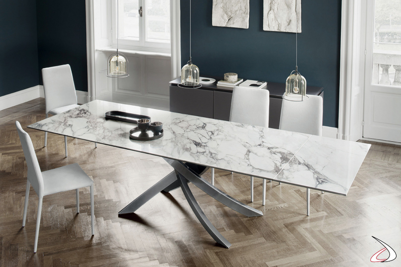 Tavolo allungabile di design con basamento in argento naturale e piano con prolunghe in supermarmo arabescato lucido