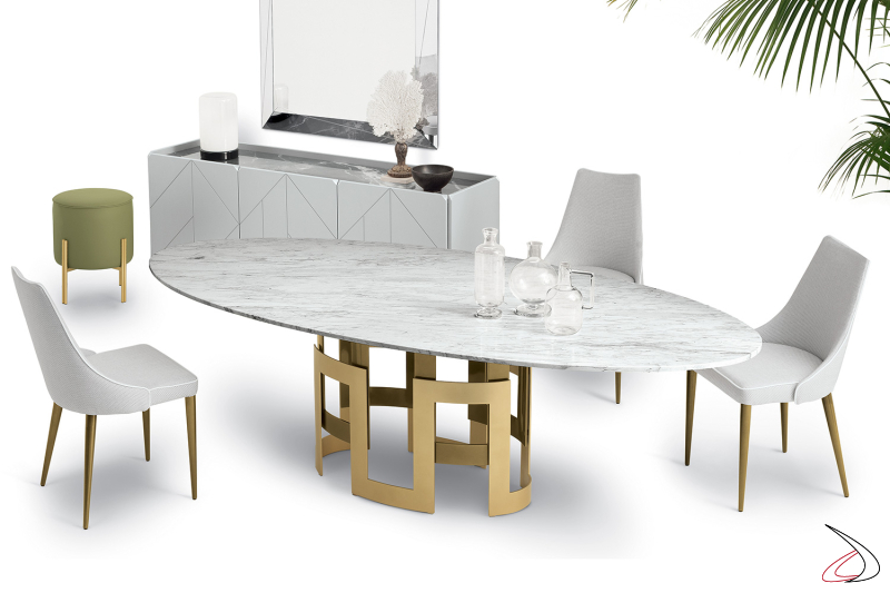 Tavolo ellittico di design con piano in marmo naturale e basamento con due bracciali in colore oro