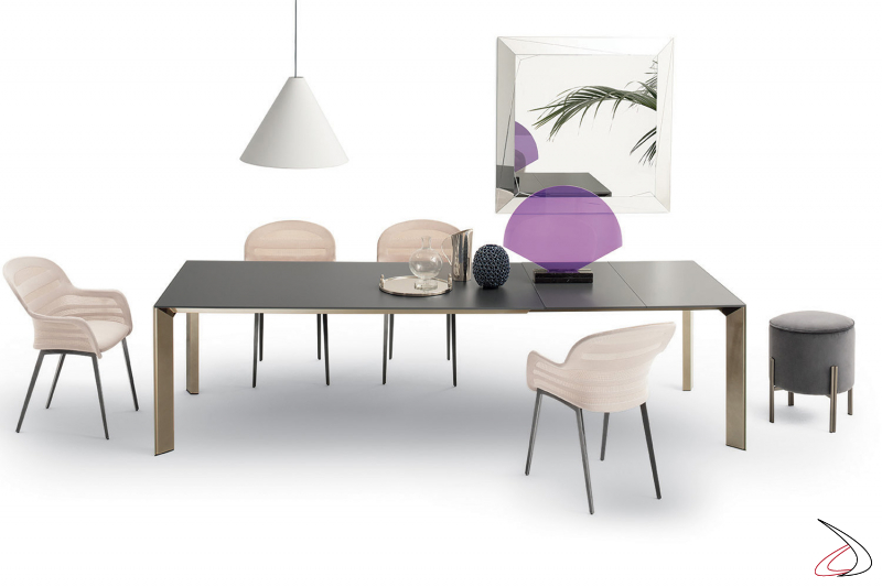 Elegante tavolo allungabile di design con piano e prolunghe in cristallo opaco nero e gambe in oro rosa