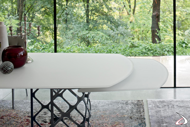 Tavolo allungabile moderno con prolunghe nascoste sotto il piano in cristallo opaco