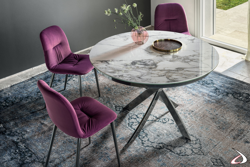 Tavolo rotondo allungabile da soggiorno con gambe intrecciate in argento naturale e piano in marmo arabescato