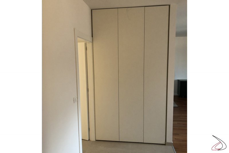 Wardrobe with hinged doors in niche flush with the wall