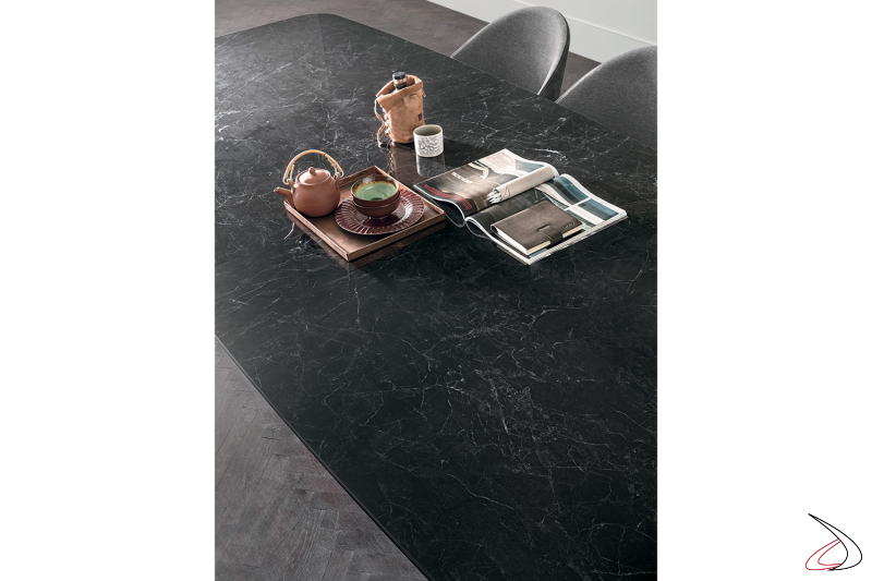 Tavolo di design con piano in ceramica nera a botte