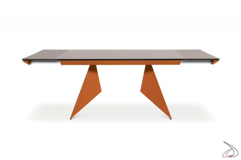 Tavolo di design allungabile con struttura arancione e piano in vetro moka