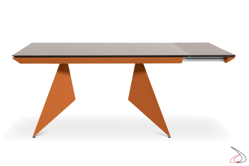Tavolo di design con piano in vetro e struttura in metallo verniciato arancione