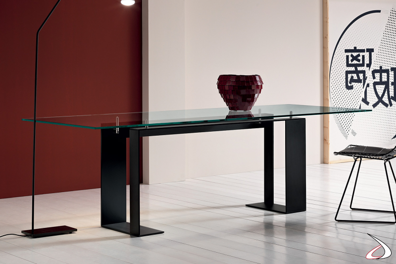 Tavolo moderno e di design con top in vetro e struttura in metallo in verniciato nero opaco.