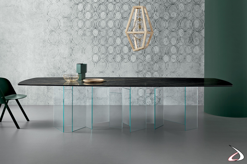 Tavolo moderno caratterizzato da un elegante top in ceramica emperador e da un basamento centrale in vetro.