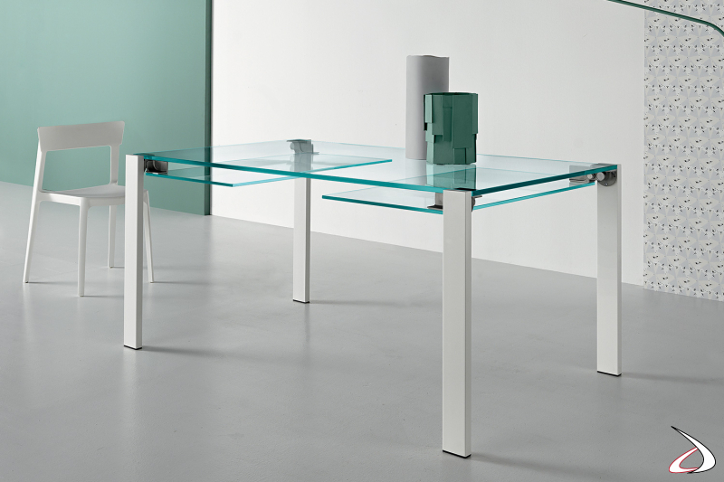 Tavolo elegante e dal design minimalista, con top allungabile in vetro e gambe in metallo verniciato bianco.