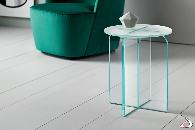 Tavolino rotondo in vetro, dal design semplice e moderno. Si caratterizza per il basamento composto da due elementi verticali che si intersecano ortogonalmente.
