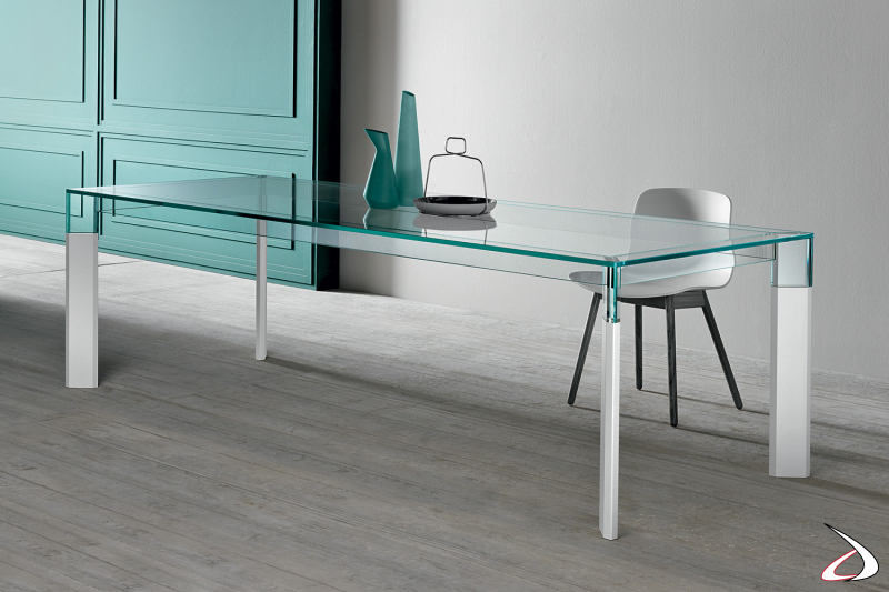 Tavolo moderno dal design minimalista e raffinato con top in vetro e gambe in laccato bianco.