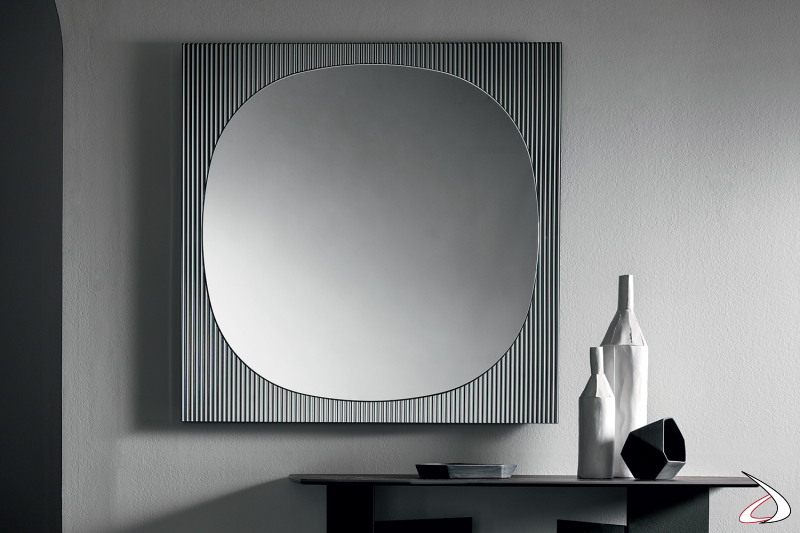 Specchio moderno e di design dagli angoli smussati, caratterizzato da una cornice squadrata realizzata dall'unione di uno specchio e di un vetro cannettato.