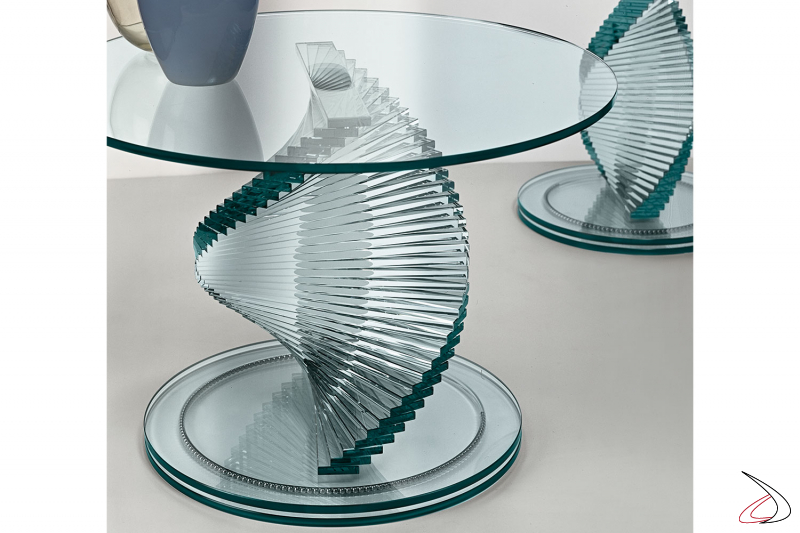 Kleiner Tisch mit Gestell und Platte aus transparentem Glas. Die zentrale Säule hat eine spezielle Konstruktion mit spiralförmig angeordneten Lamellen, die auf einem patentierten System ruhen, das aus einem auf Stahlkugeln rotierenden Sockel besteht.
