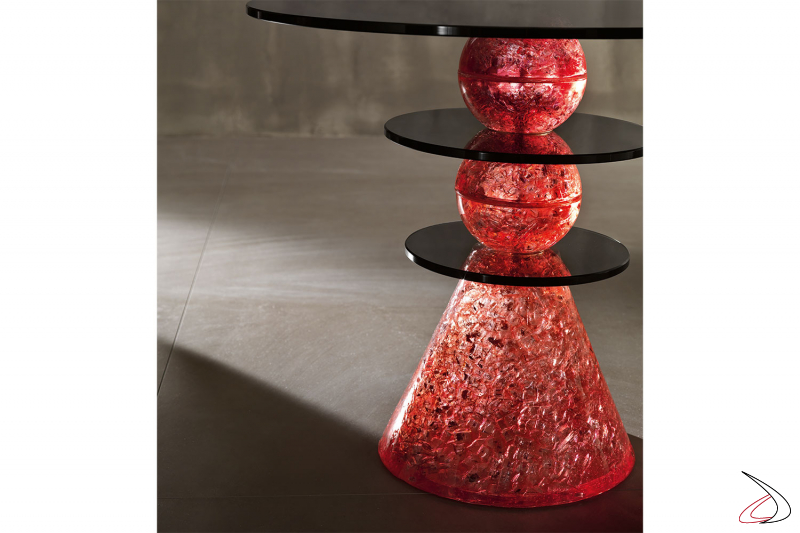 Mesa de centro Cenicienta, modelo compuesto por dos elementos esféricos sobre una base cónica en vidrio de color rojo, enriquecido por varias tapas redondas horizontales en vidrio ahumado. 
