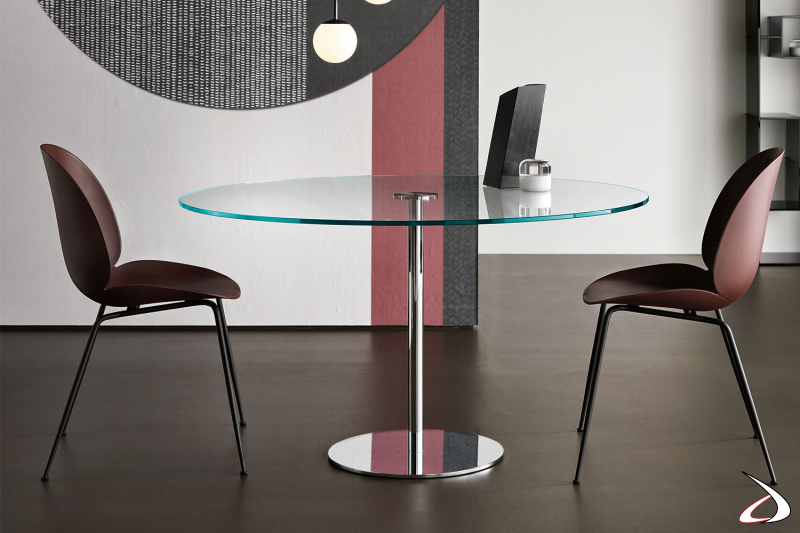Tavolo moderno rotondo con top in vetro, sostegno in metallo per dare luce all'ambiente.