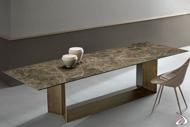 Tavolo moderno ed elegante, caratterizzato dal particolare design della struttura in metallo in bronzo spazzolato e dal piano in ceramica.