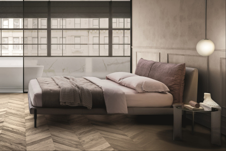Letto matrimoniale di design con giroletto in pelle e cuscini testiera in tessuto