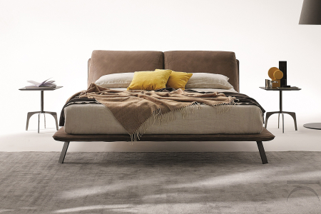 Letto di design matrimoniale con piedini alti e cuscini schienale imbottiti