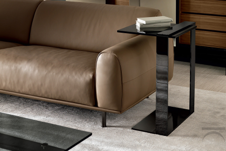 Multipurpose rectangular coffee table, characterized by an asymmetrical metal frame and a glass top.
