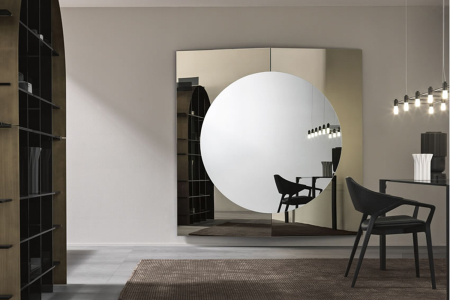 Specchio moderno di design, caratterizzato da un elemento centrale rotondo e due pannelli esterni inclinati.