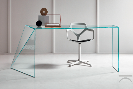 Scrivania moderna e di design in vetro, caratterizzata da un fianco irregolare composto da due lastre di vetro finemente tagliate con un taglio obliquo.