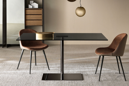 Tavolo moderno rotondo con top in vetro, sostegno in metallo per dare luce all'ambiente.
