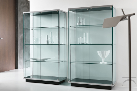 Vetrina moderna a due ante, con top e base in legno laccato e ripiani in vetro. Disponibile versione con pomolo o serratura, e kit illuminazione.