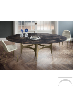 Tavolo ovale di design con piano in supermarmo e basamento centrale ad archi in color oro
